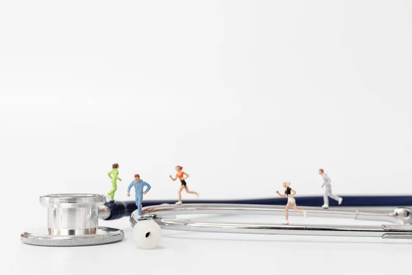 Pessoas em miniatura a correr em estetoscópio — Fotografia de Stock