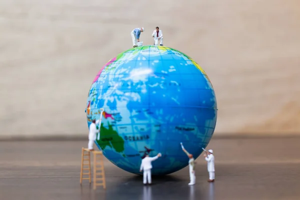 Miniature people : Painters are painting  The globe