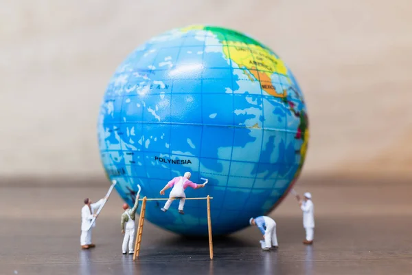 Miniature people : Painters are painting  The globe
