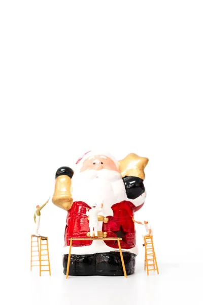Miniatuur werknemer team schilderen Kerstmis rekwisiet op witte achtergrond — Stockfoto