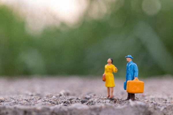 Miniature people , Traveler holding a handbag standing in the park , Travel concept