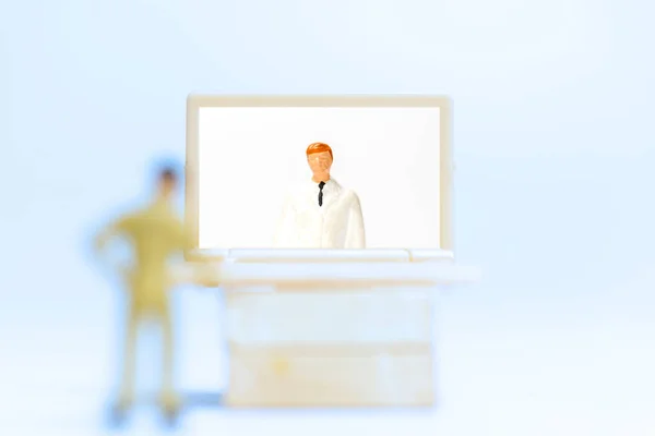 ミニチュアの人々 男性患者の話は ラップトップ上のビデオ通話を使用して医師と相談 オンライン医師の概念 — ストック写真