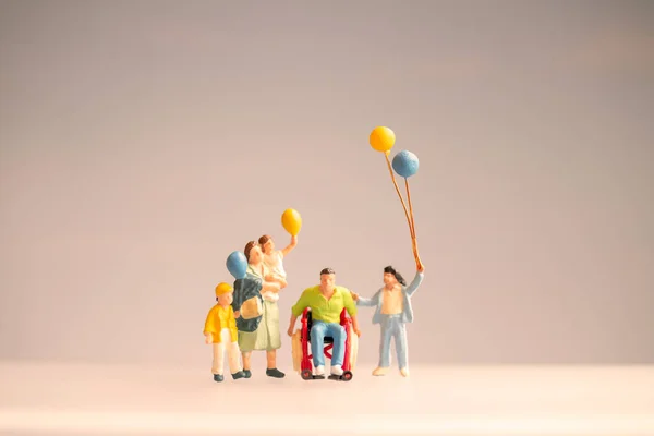 Pessoas Miniatura Família Positiva Cuidando Seu Pai Deficiente — Fotografia de Stock