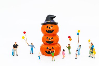 Balonlu küçük heykelcikler, cadı şapkası takmış balkabağı kulesinin etrafında toplanarak neşeli bir Cadılar Bayramı kutlamasını sembolize ediyor..