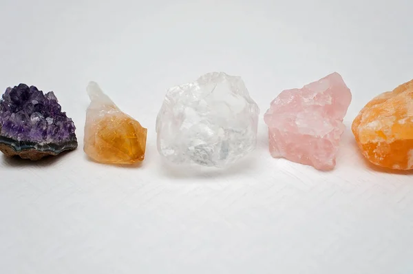 Healing crystals bring good vibes and positive vibrations: Amethyst cluster, clear quartz, citrine, calcite and rose quartz on a table