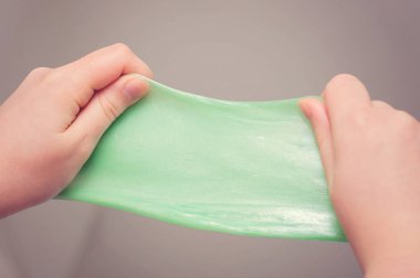Etkin bir el kabarık yeşil çamur gergin çocuklar. Sümük oynayan çocuklar etkinleştirmek için komik bir oyuncağı.