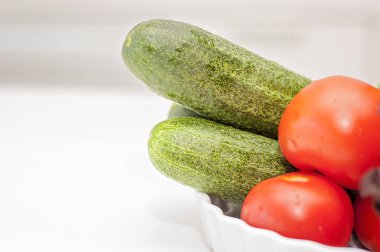 Çeşitli sebze ve meyve (domates, salata, soğan, salatalık, limon) mutfak masasında