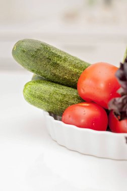 Çeşitli sebze ve meyve (domates, salata, soğan, salatalık, limon) mutfak masasında