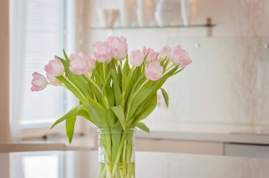 Yumuşak pembe Lale çiçek kadınlar günü kutlama için bir mutfak ile taze ve temiz ev ofis. Havadar İskandinav/Nordic iç tarzı bir medya Office Finlandiya.