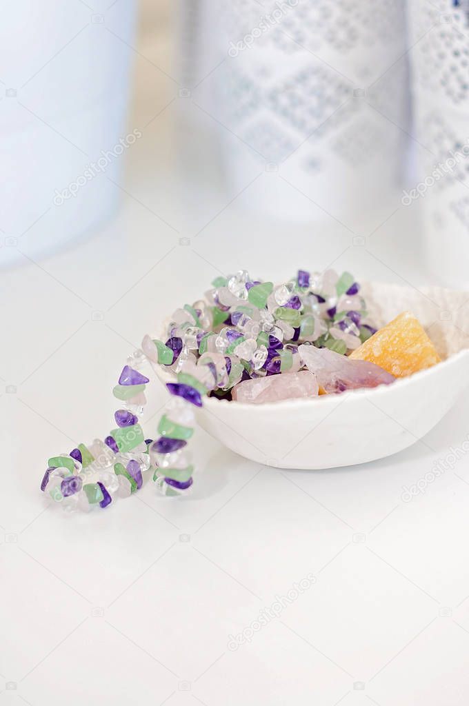 Healing crystals and gemstones on a white table: Amethyst Point, Calcite and rose quartz are bringing positive energy to support inner strength