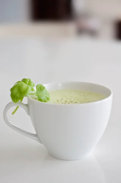 健康绿茶抹茶拿铁与大豆和燕麦牛奶在一个白色的茶杯装饰罗勒和泡沫顶部-一个温暖的饮料, 以提高大脑功能, 并作为一种癌症预防! — 图库照片