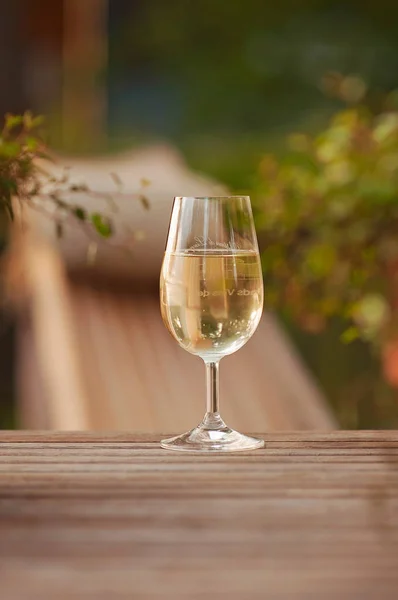 Başarısını kutlamak ve sıcak bir Yaz akşamı boyunca terasta bir kadeh şarap içerken arka planda caz çalınır. Ön planda bir şampanya bardağı ile bir Yaz parti sahne.