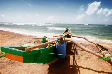 Sri Lanka kumlu okyanus plajda renkli tropikal tekne. 