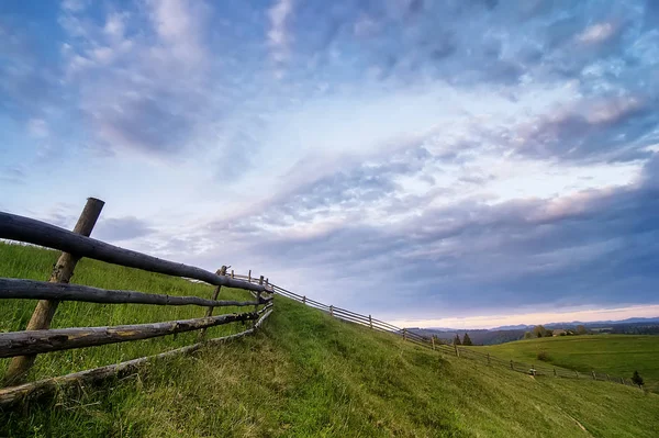 Rural wooden fence. natural summer landscape with blue cloudy sk — Stock Photo, Image