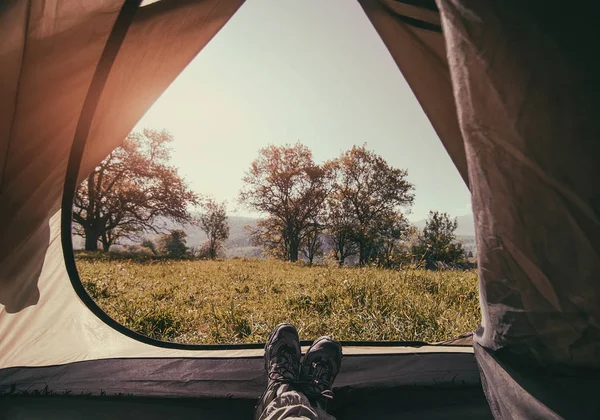 Tourists rest in a tent with a view of the mountain landscape. v