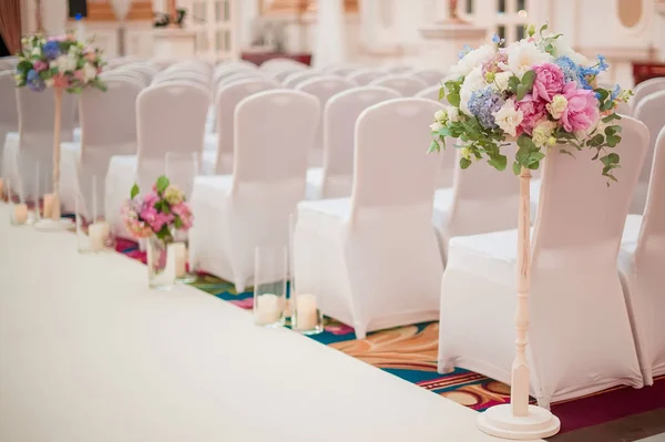 row of wedding chairs decorated with flowers
