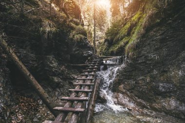 dağ şelalesi üzerinde eski ahşap merdivenler.doğal arka plan