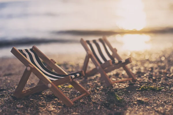 Καρέκλες παραλίας στην αμμώδη παραλία το ηλιοβασίλεμα. καλοκαιρινό φόντο. Vi — Φωτογραφία Αρχείου