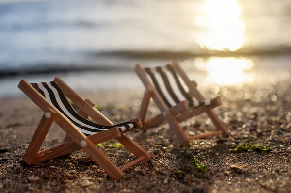 Gün batımında kum sahilde plaj sandalyeleri. yaz arka plan — Stok fotoğraf