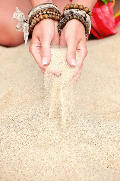 Giovane donna mani che tengono sabbia sulla spiaggia. estate naturale indietro — Foto Stock