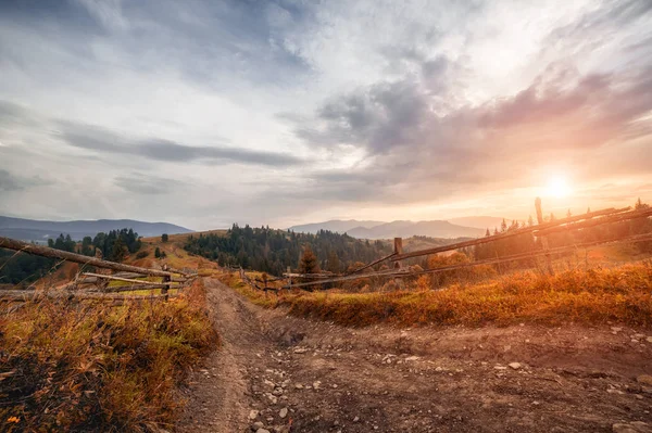 Oude houten hek, landelijke weg en top van de berg op horizon op — Stockfoto