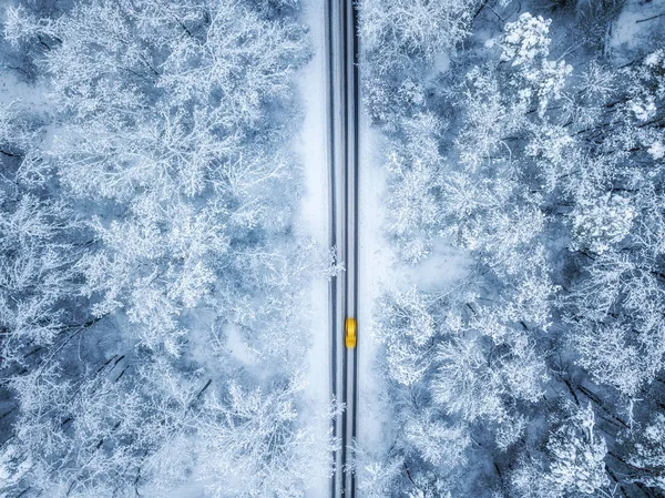 Vista aérea de la carretera de invierno y los coches que pasan por el bosque en la montaña — Foto de Stock