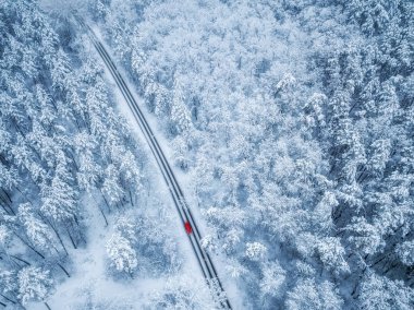 Mou orman dan geçen kış yolu ve kırmızı araba havadan görünümü