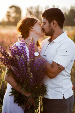 alanında romantizm lupines buketi ile genç çift 
