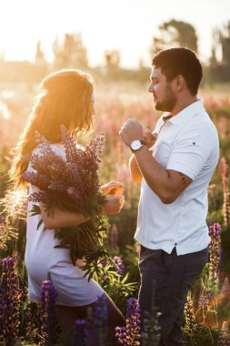 alanında romantizm lupines buketi ile genç çift 