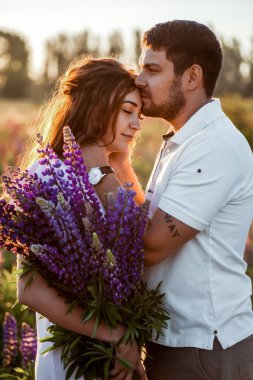 alanında romantizm lupines buketi ile genç çift 