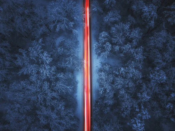 Vista aérea de la carretera de invierno noche y los coches que pasan por el bosque en — Foto de Stock