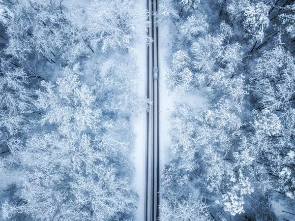 Vista aérea de la carretera de invierno y los coches que pasan por el bosque en la montaña — Foto de Stock