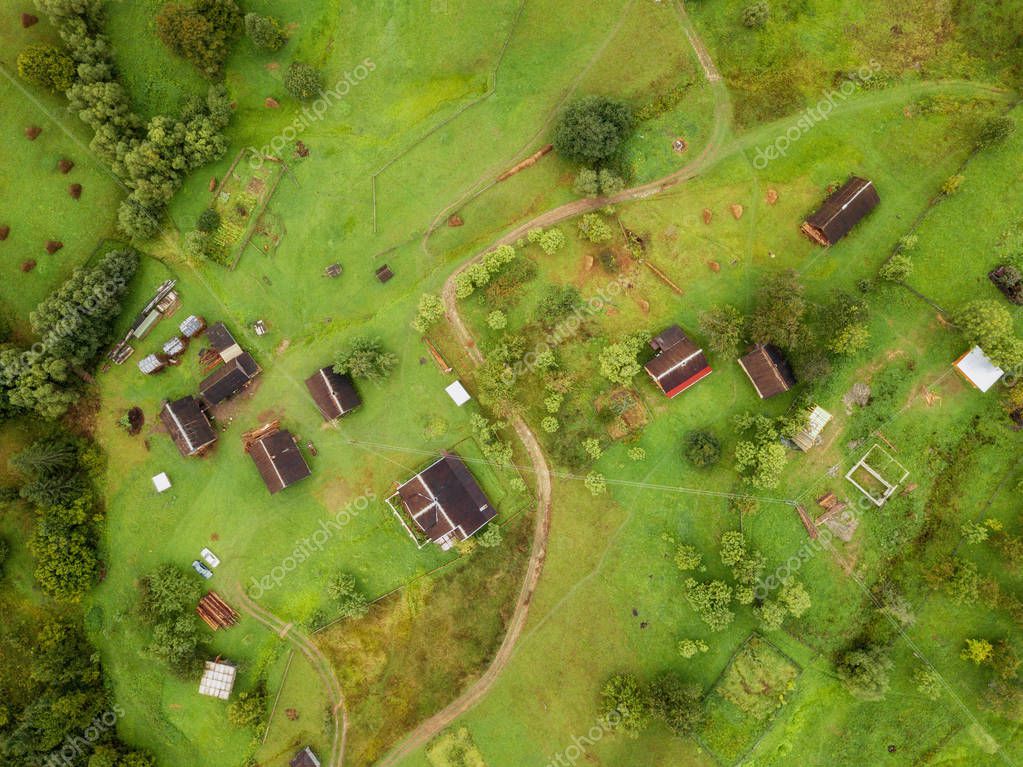 Arial veiw of rural road, green field, trees and buildings. drone shot