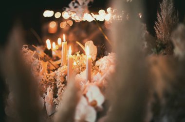 Mum ve çiçeklerle süslenmiş düğün ziyafeti..