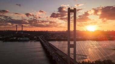 Hava gece şehir manzarası, aydınlık binalar ve köprü. İHA atışı.