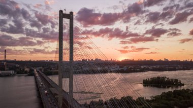 Hava gece şehir manzarası, aydınlık binalar ve köprü. İHA atışı.