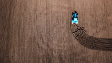 Traktörün hava görüntüsü, ekili alanı birleştirin. İHA atışı. Metin için boşluğu olan resim. Yukarıdan gelen tarlalar