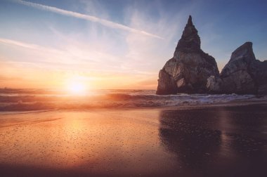 Güzel Atlantik Okyanusu manzaralı ufuk, kumlu sahil, gün batımında kayalar ve dalgalar. Sintra, Portekiz