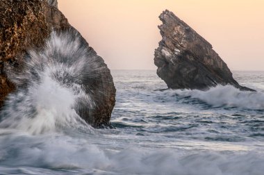 Kayalar ve dalgalarla güzel bir okyanus manzarası.