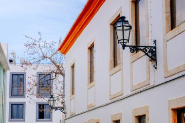 Lagos, Portekiz - 04 Mayıs 2017: Beyaz ve renkli (kırmızı, mavi, sarı ve yeşil) çiçekle süslenmiş eski Avrupa şehir caddesi.