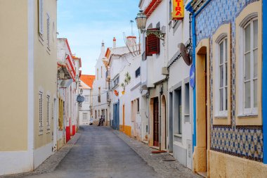 Lagos, Portekiz - 04 Mayıs 2017: Beyaz ve renkli (kırmızı, mavi, sarı ve yeşil) çiçekle süslenmiş eski Avrupa şehir caddesi.