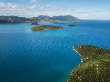 Mavi Adriyatik denizi, kumlu plaj, yeşil ağaçlar, temiz gök mavisi göl manzarası.