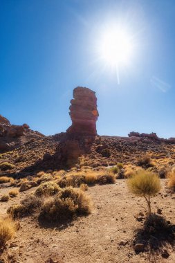 Engebeli arazide yükselen Roque Cinchado 'nun göz kamaştırıcı manzarası Teide Dağı' nın ihtişamlı arka planda yükselmesiyle Teide Ulusal Parkı, Tenerife, Kanarya Adaları, İspanya.