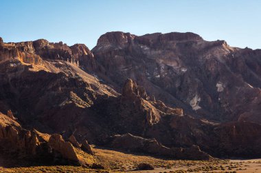 Tenerife 'deki Teide Ulusal Parkı' nın dramatik manzaralarını keşfedin, berrak mavi gökyüzü altında engebeli volkanik oluşumlar ve canlı bitkiler gösterin. Kanarya Adaları, İspanya.
