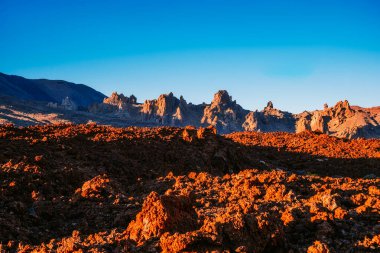 Teide Dağı Tenerife, Kanarya Adaları 'ndaki Teide Ulusal Parkı' nın kurak arazisinin üzerinde berrak mavi gökyüzünün altında volkanik bir zemin sergiliyor.