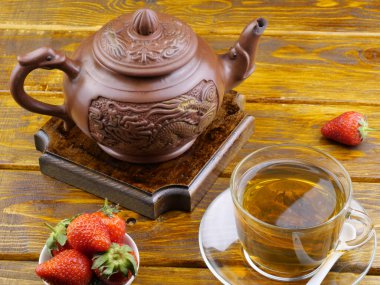 Çaydanlık, kupa ve ahşap bir masada çilek seremonisi..