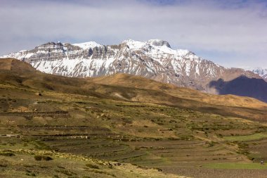 Karla kaplı Himalaya dağ kuleleri, Spiti Vadisi 'ndeki Langza köyünün etrafındaki tepelerin üzerinde..