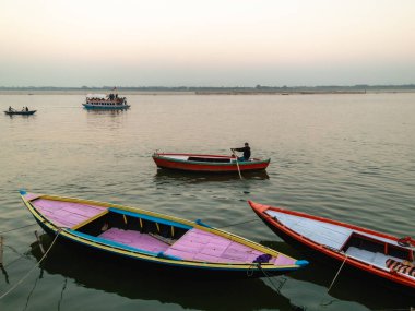 Varanasi, Uttar Pradesh, Hindistan - Şubat 2015: Antik kentin eski ghatlarının yanındaki Ganga nehrinde ahşap kayıklarla dolu bir sahne.