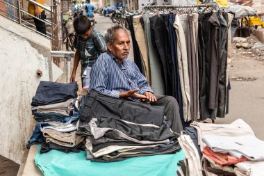 Chennai, Tamil Nadu, Hindistan - Ağustos 2018: Yol kenarında pantolon ve şort satan Hintli bir sokak satıcısı.