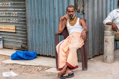 Chennai, Tamil Nadu, Hindistan - Ağustos 2018: Yol kenarında boş boş bakan ve düşünceli bakan Hintli bir adam.